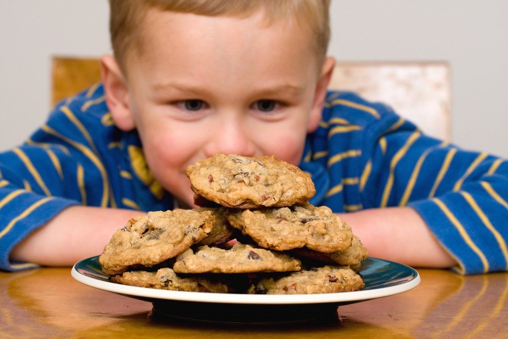 Kid looking at a plate with cookies