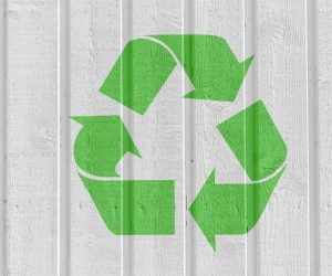 Recycling symbol on white wooden wall background