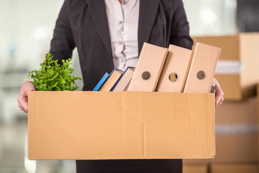 businesswoman holding cardboard box with her things