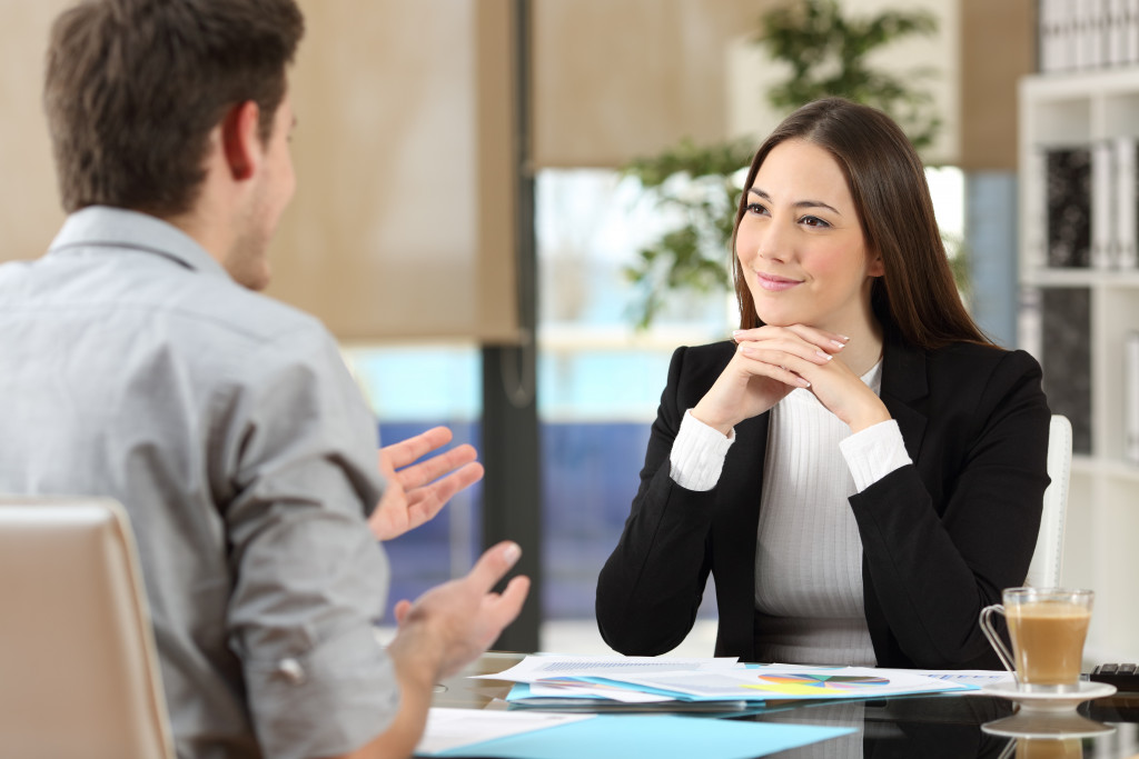 a female boss listens to his male employee
